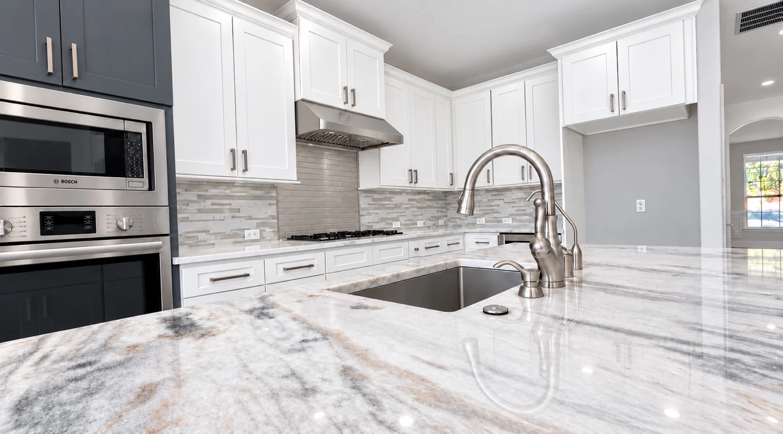 Completed Renova kitchen with white cabinetry and polished stone counters · Sugarland, Tx