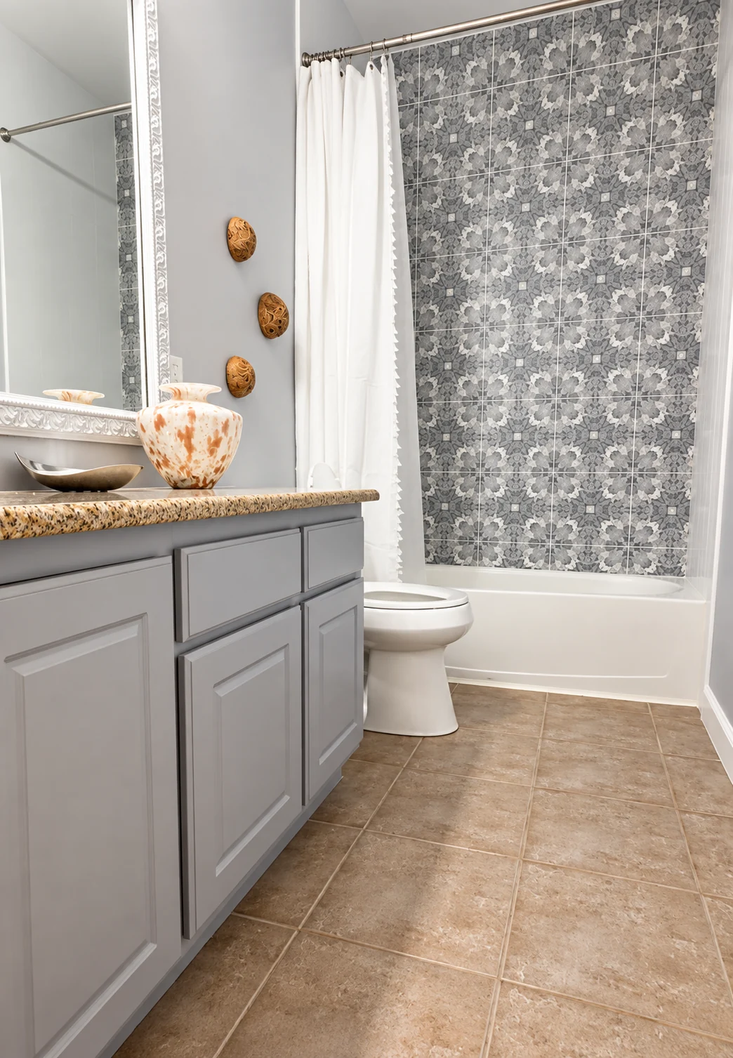 Gray vanity, patterned shower tile and coordinated bathroom finishes