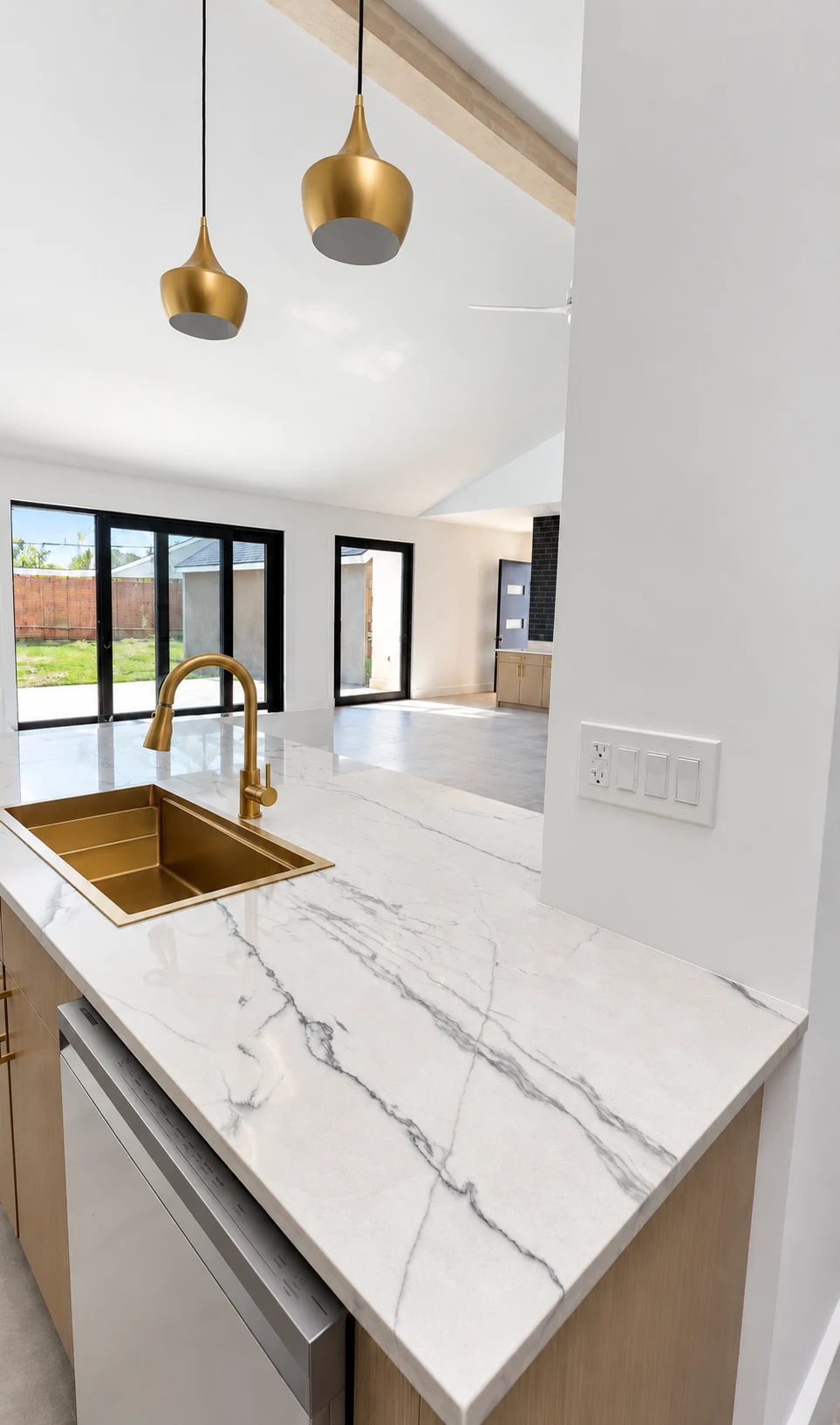 Renova kitchen with veined stone counters and gold fixtures · Woodlands Tx